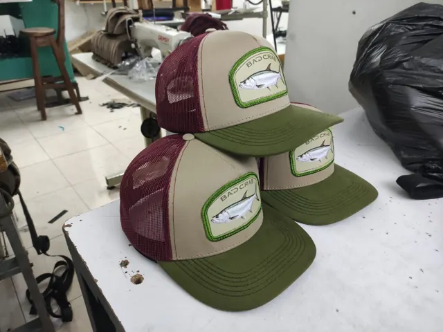 Gorras trucker con parche de sábalo real, malla vinotinto y visera verde oliva
