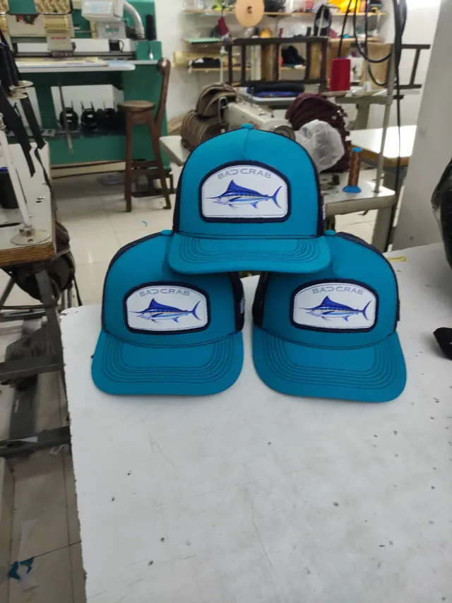 Gorras trucker turquesa con parche de marlín azul y malla azul marino